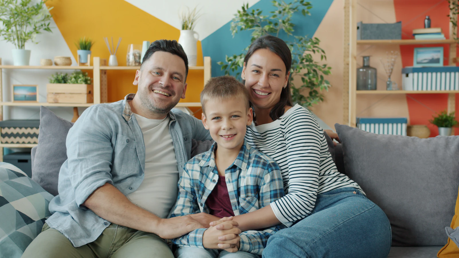 Familia feliz sentada en el sofá de su casa